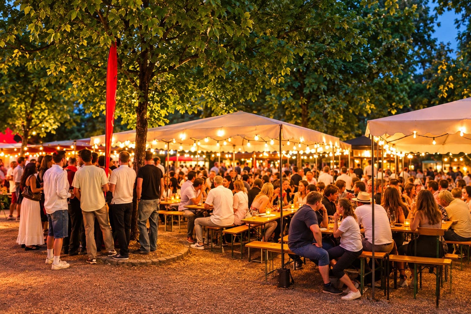 Das Weinfest im Alten Kurpark in Bad Soden: Stände und Tische zwischen alten Bäumen, Gäste mit Weingläsern.